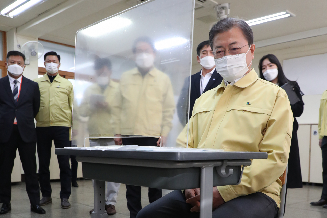 문재인 대통령이 2021학년도 대학수학능력시험을 나흘 앞둔 29일 오후 자가격리 수험생을 위한 별도시험장이 마련된 서울 용산구 오산고등학교를 방문, 수험생 자리에 직접 앉아 시험장 칸막이 이격 거리를 살펴보는 등 방역 준비 상황을 점검하고 있다. [연합]