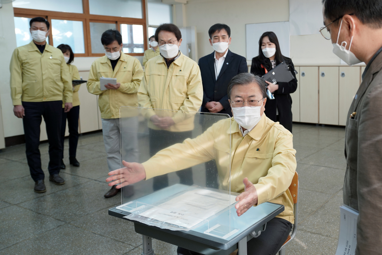 문재인 대통령이 2021학년도 대학수학능력시험을 나흘 앞둔 29일 오후 자가격리 수험생을 위한 별도시험장이 마련된 서울 용산구 오산고등학교를 방문, 수험생 자리에 직접 앉아 칸막이를 살피는 등 방역 준비 상황을 점검하고 있다. [연합]