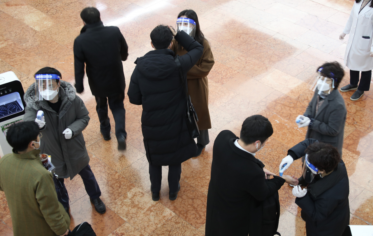 국내 신종 코로나바이러스 감염증(코로나19) '3차 대유행'이 진행 중인 가운데 30일부터 정부서울청사 현관에서 출근하는 공무원들에게 체온 측정을 하고 손 소독제를 사용한 후 청사로 들어오도록 하고 있다. 연합뉴스