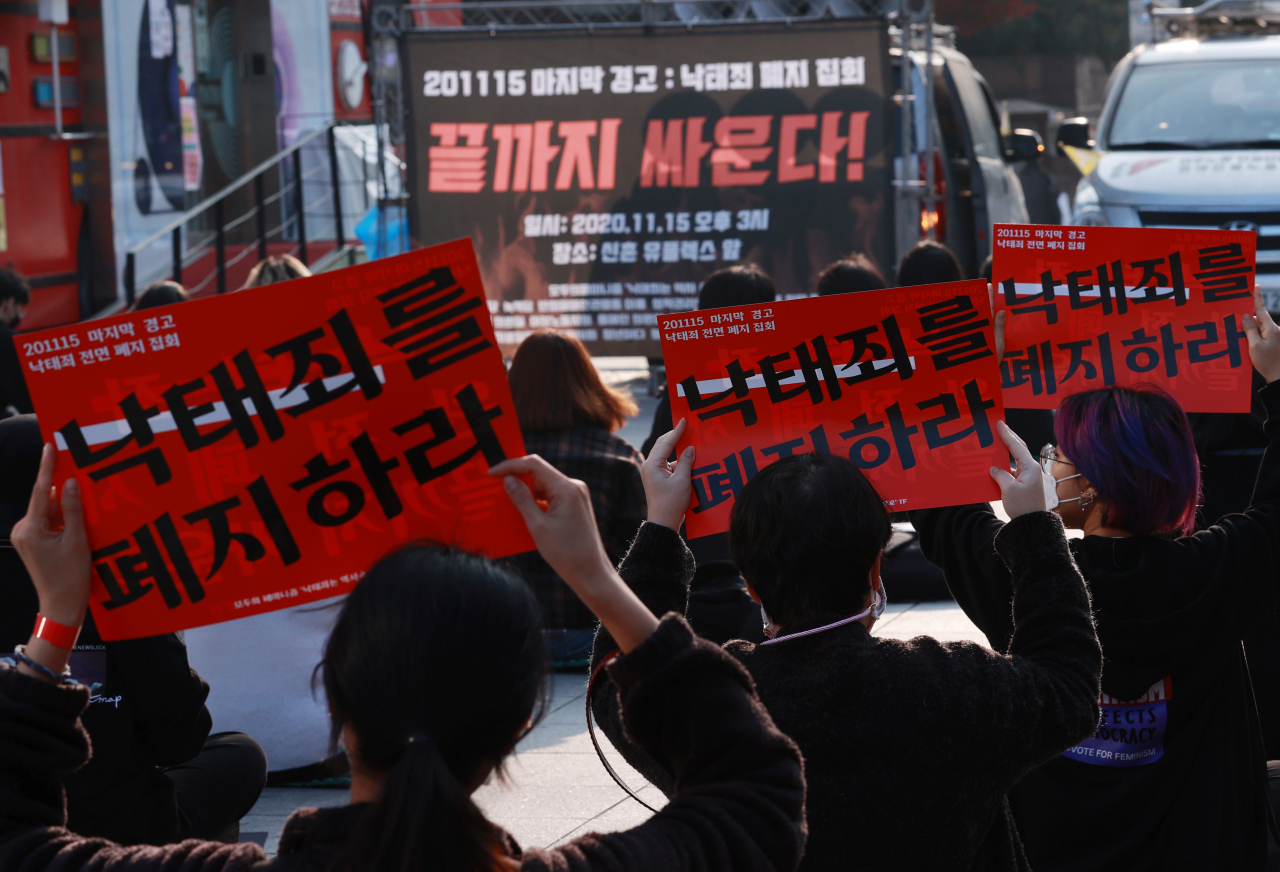 지난 15일 서울 서대문구 신촌 유플렉스 앞에서 열린 낙태죄 전면 폐지 촉구 집회에서 참가자들이 팻말을 들고 구호를 외치고 있다. [연합]