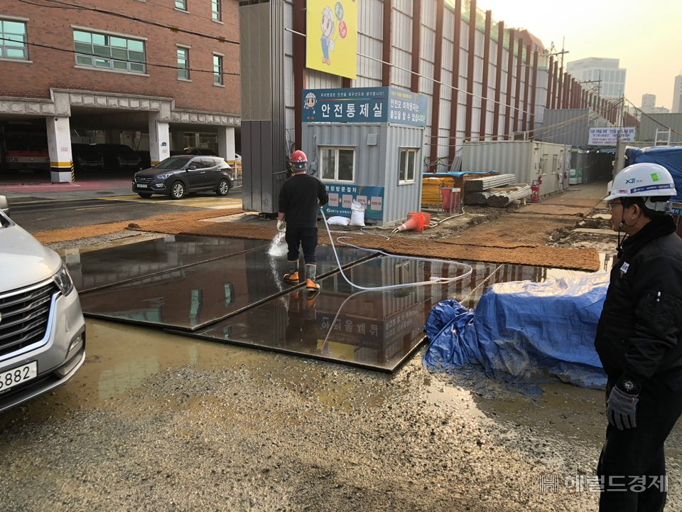 공사장의 비산먼지를 방지하기 위해 공사장 입구에 물을 뿌리고 있다.