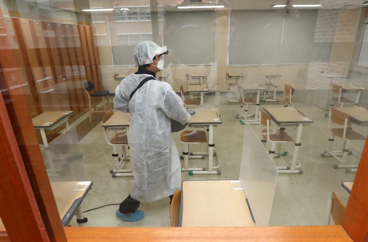 2021학년도 대학수학능력시험일을 하루 앞둔 2일 세종시 한 고등학교에 마련된 시험장에서 방역 관계자들이 신종 코로나바이러스 감염증(코로나19) 소독 작업을 하고 있다. [연합]