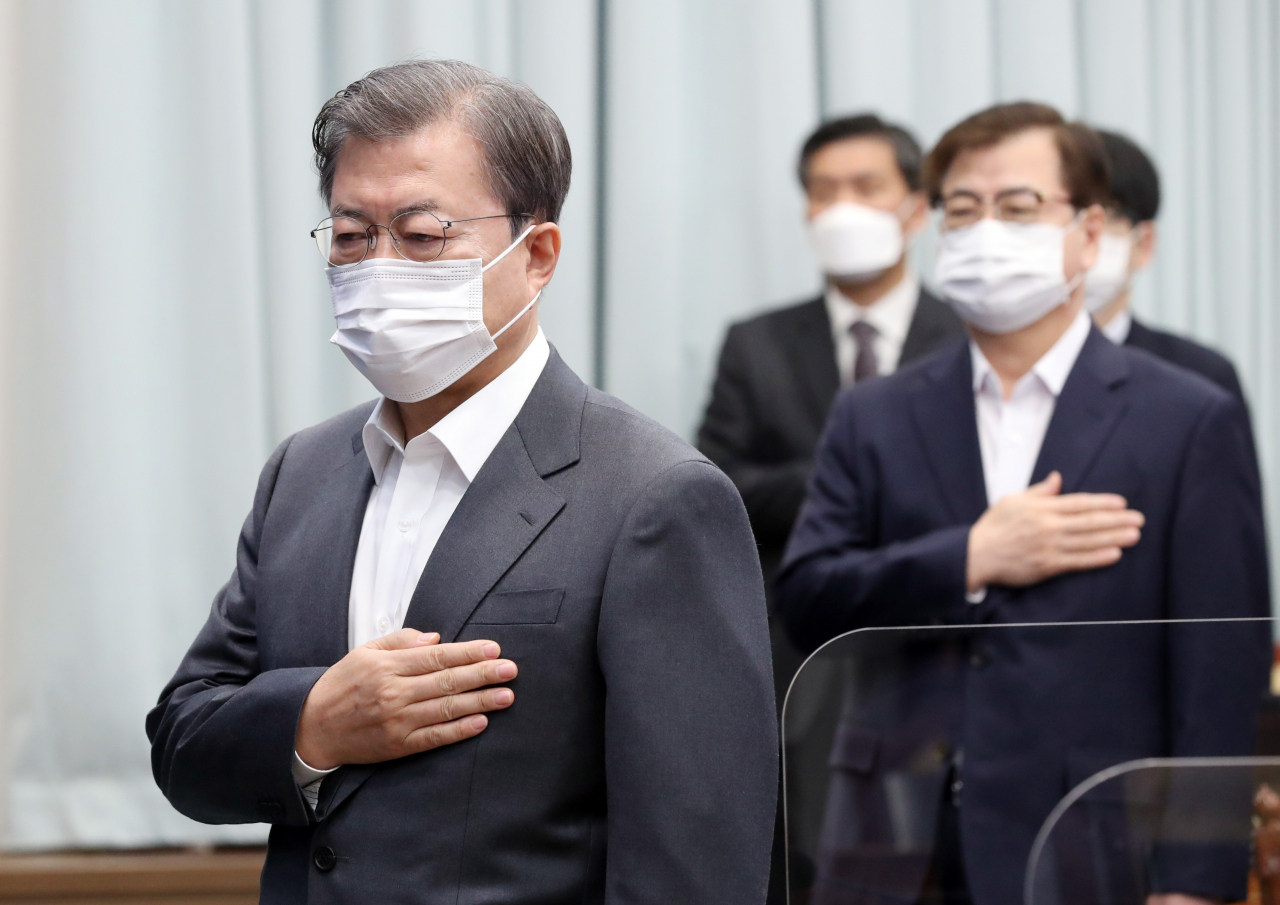 문재인 대통령이 1일 오전 청와대에서 열린 영상 국무회의에서 국기에 경례하고 있다. [연합]