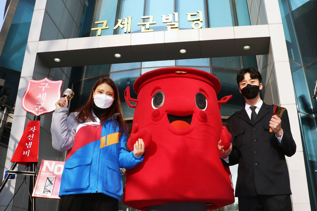 CJ대한통운 직원(왼쪽)과 구세군 직원이 구세군 캐릭터 '따끈이'와 함께 기념촬영을 하고 있다.[CJ대한통운 제공]