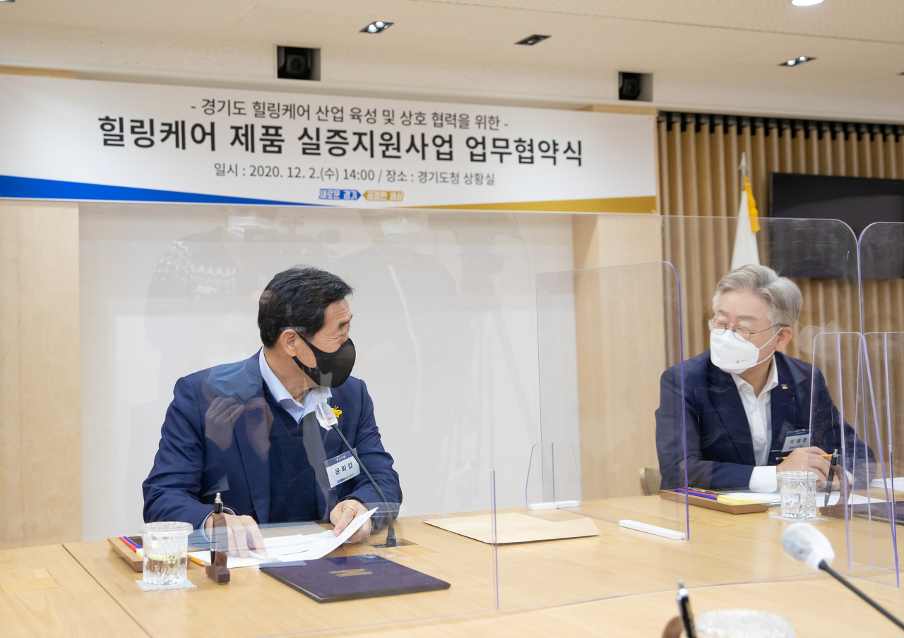 윤화섭 안산시장이 경기도청 상황실에서 열린 힐링케어 제품 실증지원사업 업무협약식에서 이재명 경기지사와 대화를 나누고 있다. [경기도 제공]