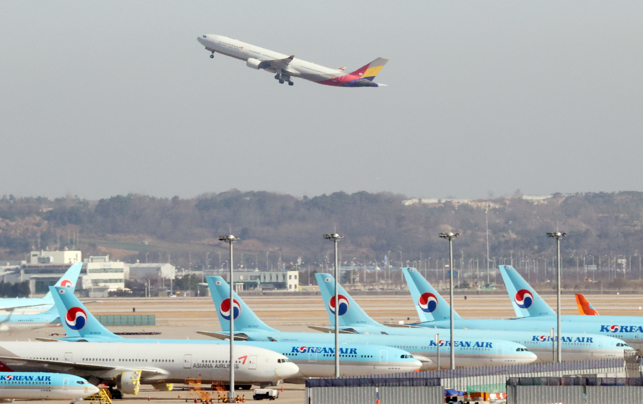 대한항공·아시아나항공 노조가 노사정회의체를 통한 고용 안정 대책 마련을 재차 요구했다. 인천국제공항에 대한항공과 아시아나항공 양사 여객기들이 주기돼 있는 모습. [연합뉴스]