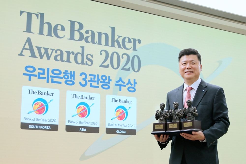 온라인으로 진행된 더 뱅커(The Banker)의 글로벌 최우수 은행 시상식에서 권광석 우리은행장이 3개 부문 수상 트로피를 들고 기념촬영을 하고 있다. [우리은행 제공]