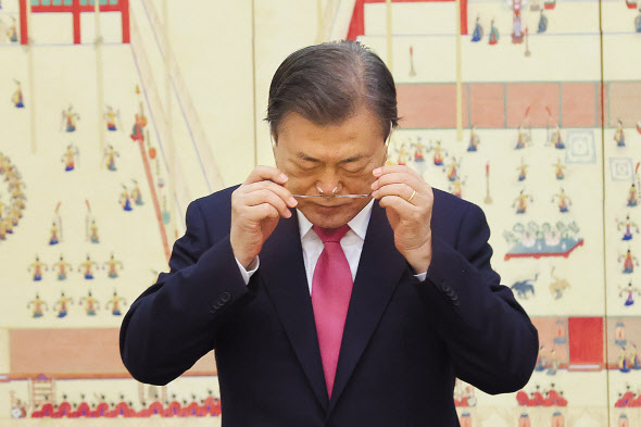문재인 대통령이 2일 청와대에서 신임 대사들에게 신임장을 수여한 뒤 기념촬영에 앞서 안경을 고쳐쓰고 있다. [연합]