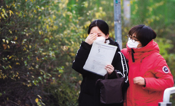 2021학년도 대학수학능력시험일인 3일 오전 서울 영등포구 여의도여자고등학교에서 마스크 쓴 수험생이 가족들의 응원 속에 고사장으로 향하고 있다. 이상섭 기자