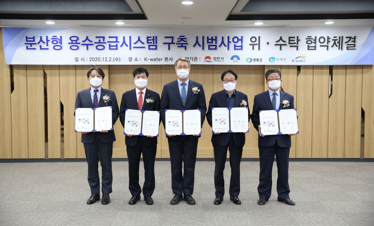 지난 2일 대전시 대덕구 한국수자원공사 본사에서 열린 물 이용 취약지역 주민 물복지 향상을 위한 ‘분산형 용수공급시스템 구축 시범사업 위·수탁 협약’ 체결식에서 참석자들이 기념 촬영을 하고 있다. 왼쪽부터 변영섭 양평군 부군수, 김재광 김천시 부시장, 박재현 한국수자원공사 사장, 최상기 인제군 군수, 이선호 영동군 부군수. [한국수자원공사 제공]