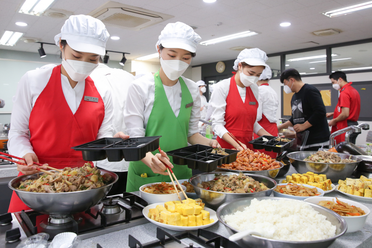 티웨이항공 사내 봉사 동아리 ‘쉼 봉사’ 소속 직원들이 보육원 아이들과 구급대원을 위한 도시락을 만들고 있다. [티웨이항공 제공]