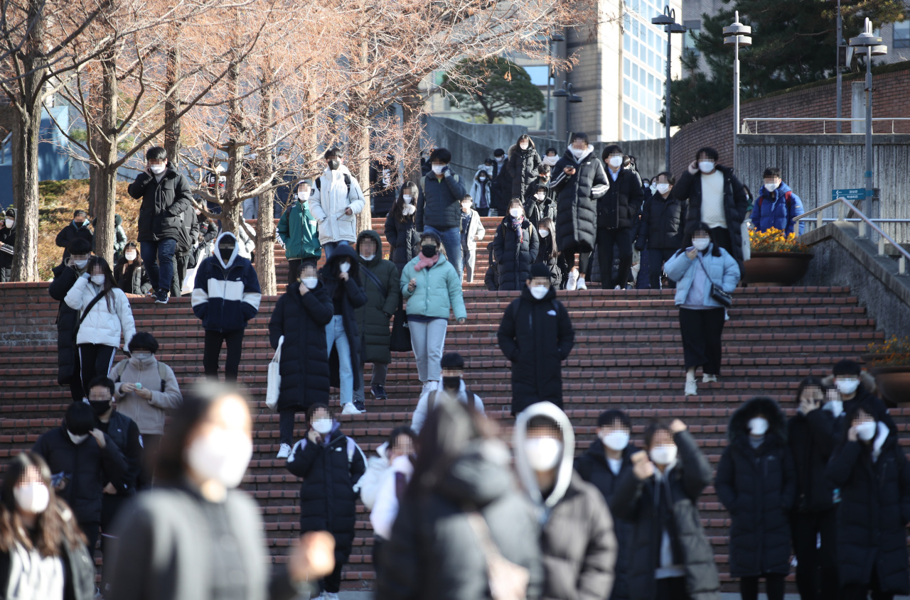 Students walk out of a building Friday after completing the written exam for earliy admissions at Soongsil University. (Yonhap)