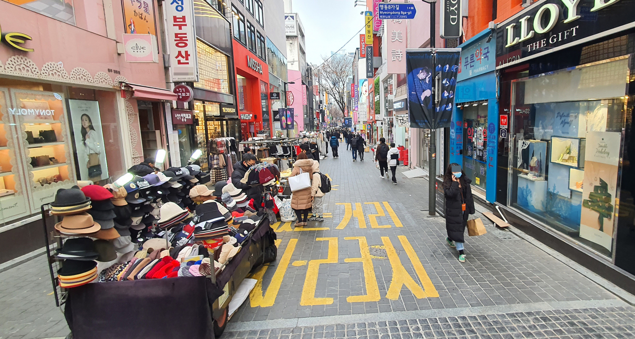 정부는 수도권 사회적 거리두기를 2.5단계로 격상해 연말까지 3주간 유지한다고 6일 밝혔다. 2.5단계가 되면 노래연습장, 실내체육시설의 운영이 중단되고 마트와 백화점, 영화관, PC방 등은 밤 9시 이후 문을 닫는다. 사진은 이날 명동거리 모습. [연합뉴스]
