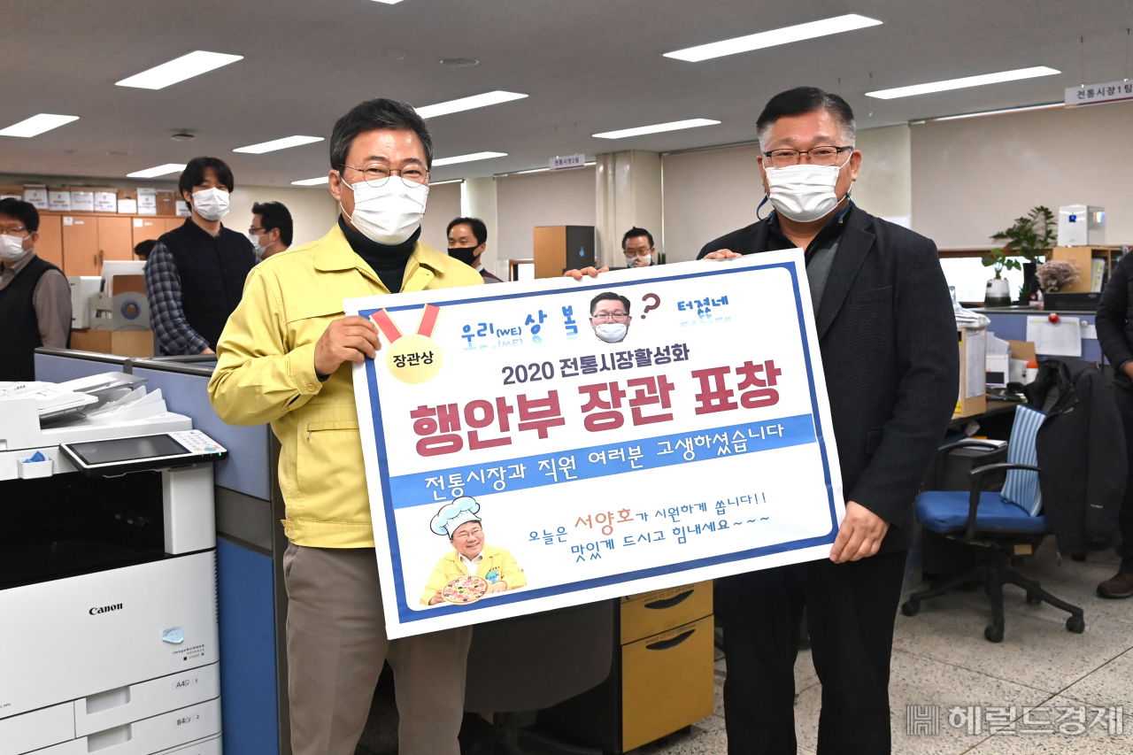 지난 4일 서양호 중구청장(왼쪽)이 부서 직원들이 간식으로 먹을 피자를 가지고 전통시장과를 방문해 행안부 장관 표창을 받은 직원들을 격려하고 기념촬영을 하고 있다. [중구 제공]