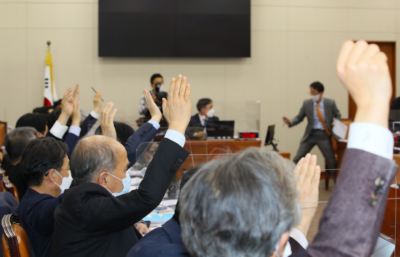 7일 밤 국회에서 열린 정무위원회 전체회의에서 진행된 '사회적 참사의 진상규명 및 안전사회 건설 등을 위한 특별법, 금융그룹 감독법, 공정거래법' 등 안건 변경 상정에 대한 표결에서 더불어민주당 의원들은 손을 들어 찬성하는 반면 국민의힘 의원들 반대하고 있다.[헤럴드경제=이상섭 기자]