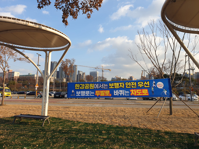 자전거와 PM의 지정도로 운행을 알리는 현수막이 걸려 있다. [서울시 제공]