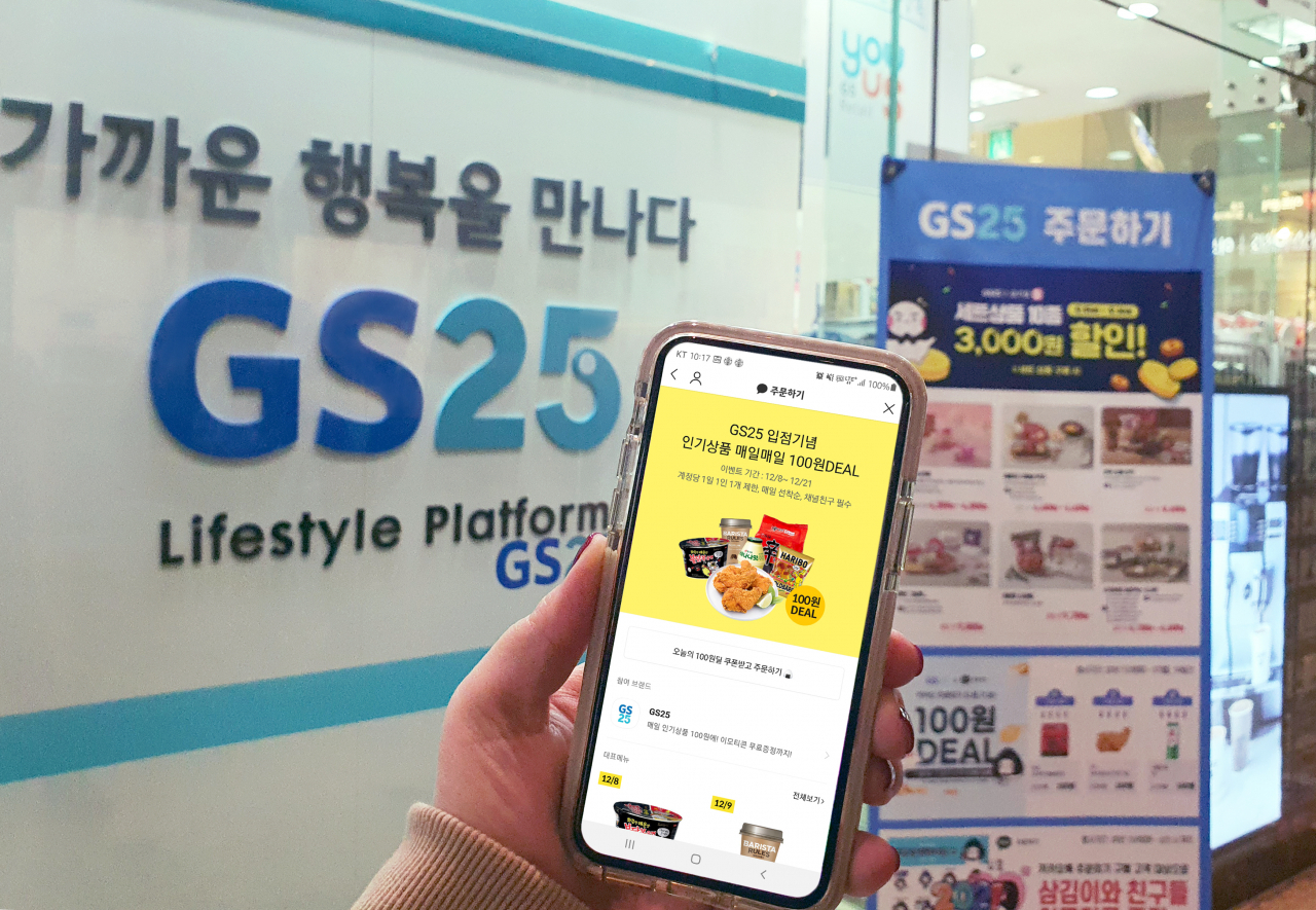 고객이 GS25 매장 앞에서 '카카오톡 주문하기' 100원딜을 살펴보고 있다. [사진제공=GS25]