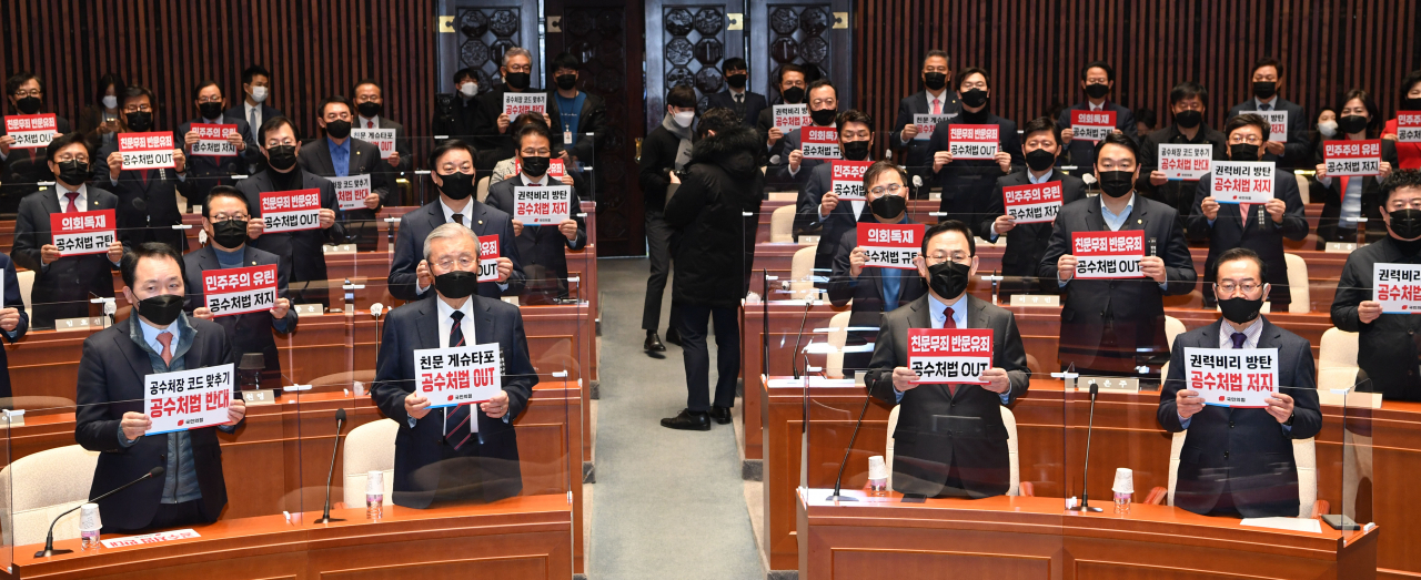 김종인 국민의힘 비상대책위원장과 주호영 원내대표가 9일 국회에서 열린 비상의원총회에서 손팻말을 들고 고위공직자범죄수사처(공수처)법 아웃을 외치고 있다. [연합]