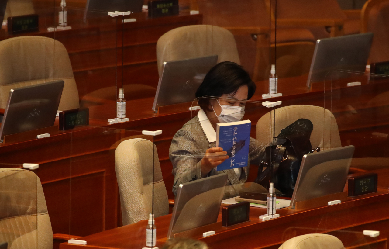 추미애 법무부 장관이 9일 국회 본회의를 앞두고 본회의장 장관석에 앉아 '내가 검찰을 떠난 이유'라는 책을 가방에서 꺼내고 있다. [연합]