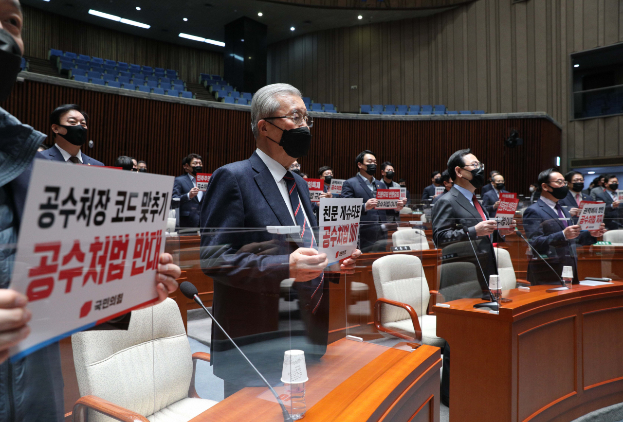 김종인 국민의힘 비상대책위원장과 주호영 원내대표, 의원들이 9일 국회에서 열린 비상의원총회에서 더불어민주당의 공수처법 개정안 입법 강행을 규탄하는 피켓을 들고 있다. [헤럴드경제=이상섭 기자]