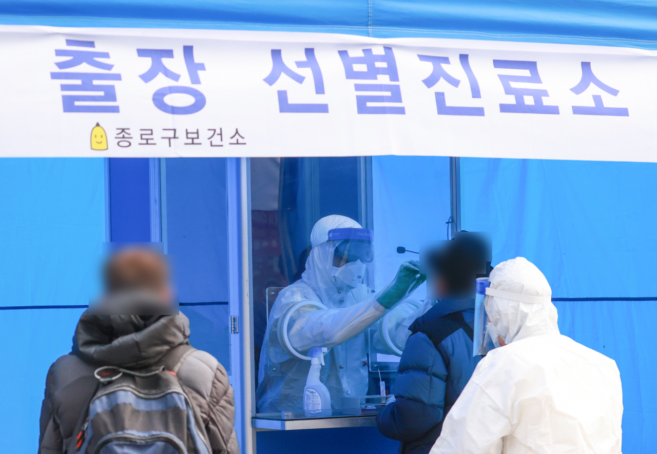 지난 9일 오후 종로구 보건소 관계자들이 파고다타운 인근 거리에 출장 선별진료소를 설치하고 상인과 이용객 등을 상대로 검체 채취를 하고 있다. [연합]