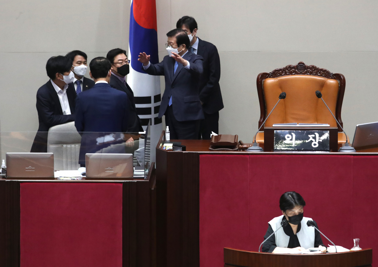 국민의힘 윤희숙 의원이 12일 오전 국회 본회의에서 국가정보원법 전부개정 법률안에 대한 무제한 토론(필리버스터)을 하는 동안 박병석 국회의장이 전날 필리버스터를 한 의원 중 한 명이 코로나19 확진자와 접촉했다는 소식을 전달받고 더불어민주당 조승래 의원, 국민의힘 김성원 원내수석부대표 등과 방역을 위한 정회를 논의하고 있다. [연합]