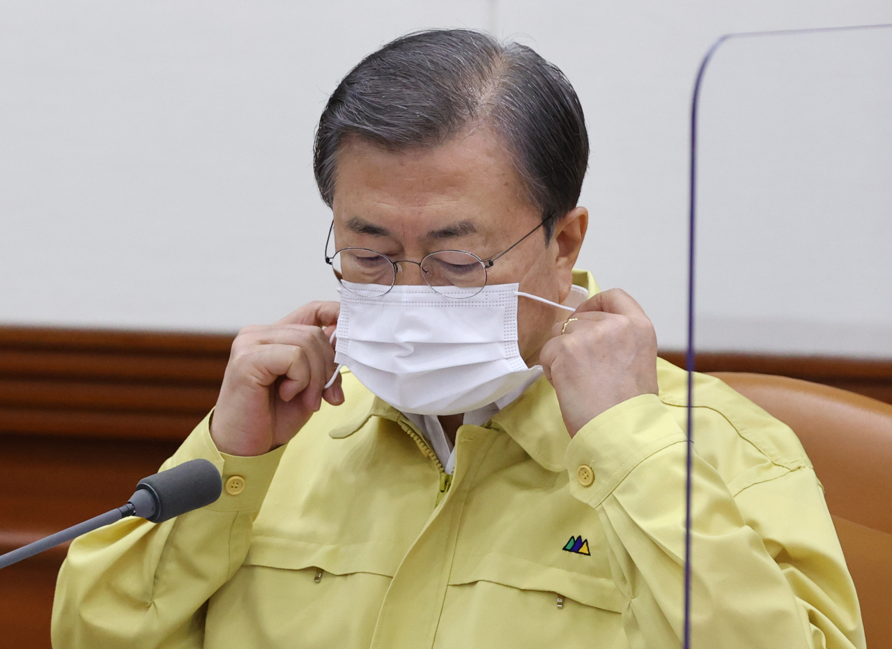 문재인 대통령이 13일 오후 정부서울청사에서 열린 신종 코로나바이러스 감염증(코로나19) 대응 긴급 중앙재난안전대책본부(중대본) 회의에 참석, 발언에 앞서 마스크를 벗고 있다. [연합]