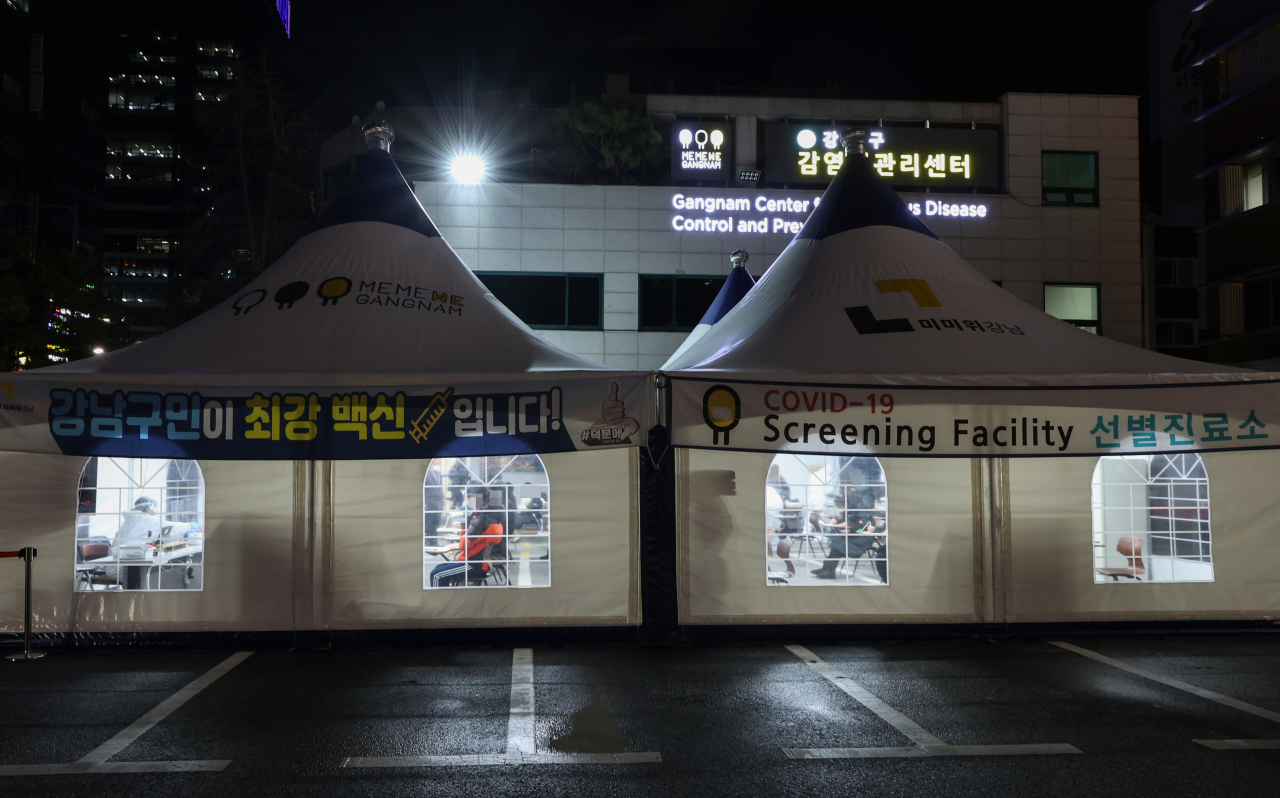 13일 오후 서울 강남구 보건소 선별진료소를 찾은 시민들이 신종 코로나바이러스 감염증(코로나19) 검체 채취를 위해 문진표를 작성하며 차례를 기다리고 있다. 연합뉴스