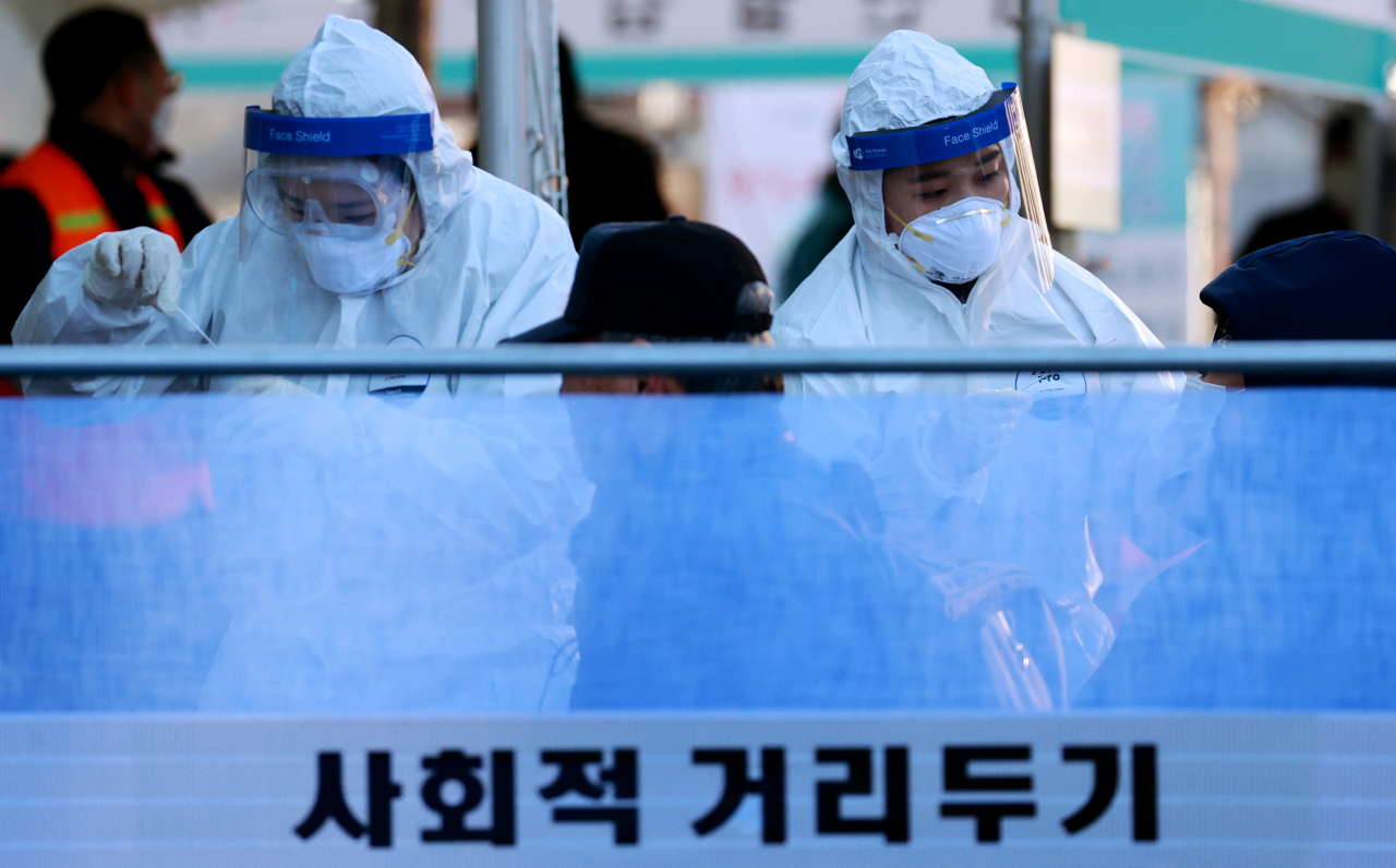 지난 16일 오전 서울역 광장에 설치된 중구 임시선별진료소에서 의료진이 신종 코로나바이러스 감염증(코로나19) 검체 채취를 하고 있다. [연합]