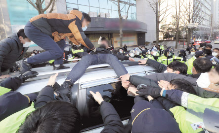 지난 12일 경기도 안산시에서 한 시민이 조두순의 호송차량에 올라타 발길질을 하고 있다.[연합]