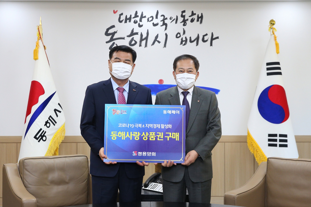 쌍용양회가 지역경제 활성화를 위해 생산공장 임직원들에 100만원씩 지역사랑상품권을 지급했다. 사진은 심규언 동해시장, 원용교 쌍용양회 동해공장장. [쌍용양회 제공]
