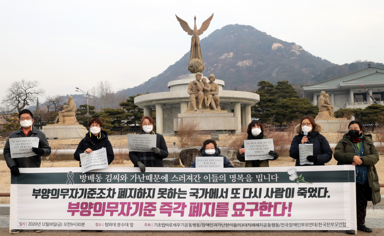 18일 서울시 종로구 청와대 분수대 앞에서 열린 '방배동 김씨를 추모하는 기자회견'에서 기초법바로세우기공동행동 등 시민단체 회원들이 부양의무자기준 폐지공약의 이행을 촉구하고 있다. [연합]