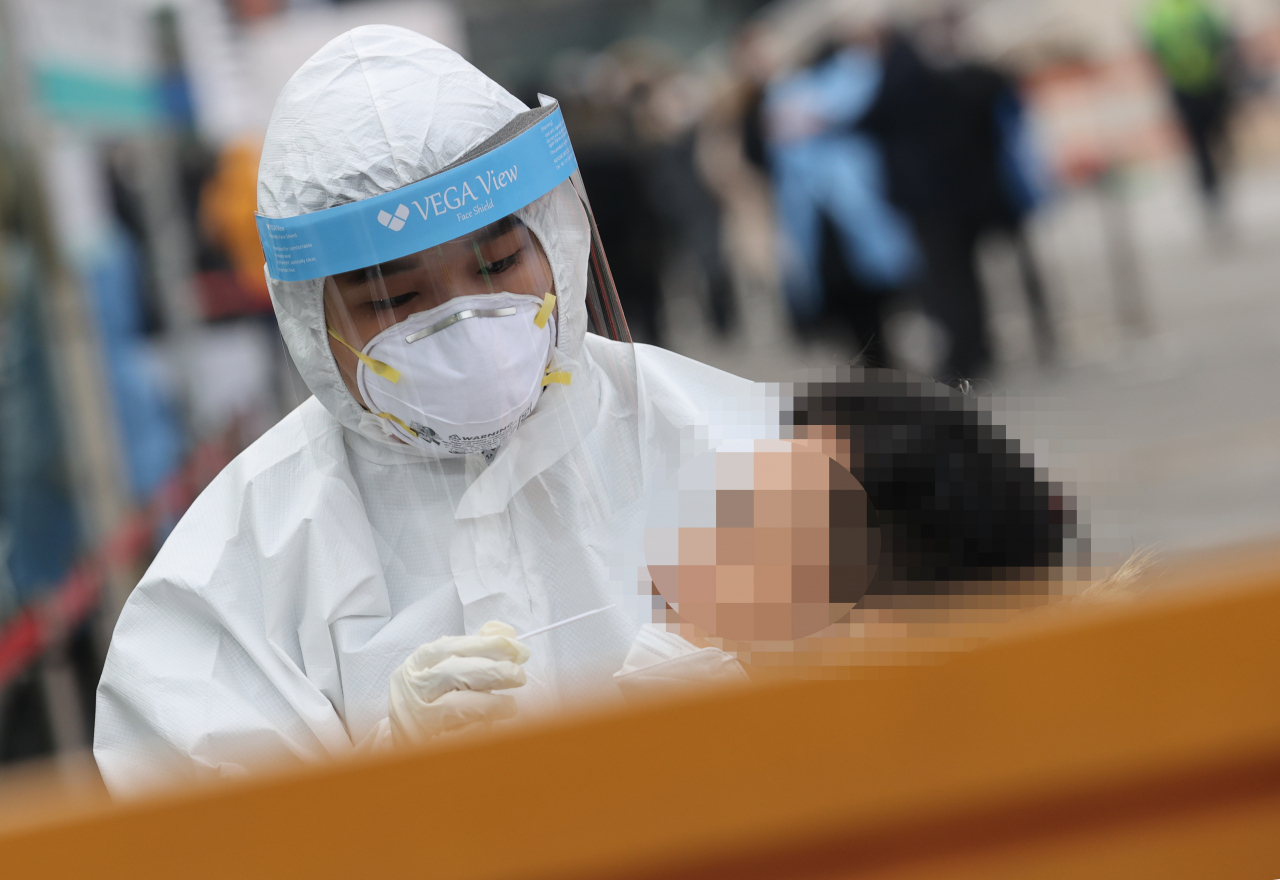 17일 오전 서울역 광장에 설치된 중구 임시 선별검사소에서 의료진이 검체를 채취하고 있다. 중앙방역대책본부는 18일 0시 기준으로 코로나19 신규 확진자가 1062명 늘어 누적 4만7515명이라고 밝혔다. [연합]