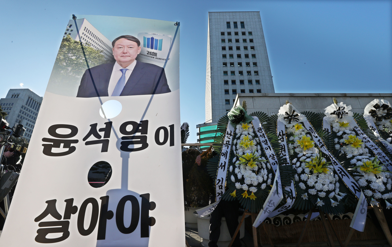 Signs and flowers are placed in front of the Supreme Prosecutors' Office in Seocho-gu, southern Seoul, on Thursday in support of Prosecutor General Yoon Seok-youl. With the two-month suspension under effect, the prosecution is under the leadership of acting Prosecutor General Cho Nam-kwan. (Yonhap)