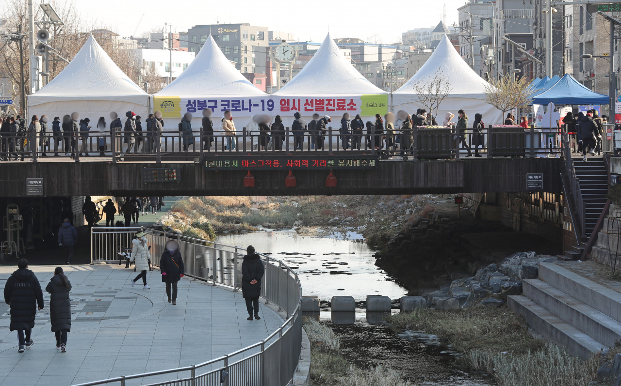 18일 오후 서울 성북구청 앞 임시 선별진료소에서 시민들이 코로나19 검사를 받기 위해 차례를 기다리고 있다. [연합]