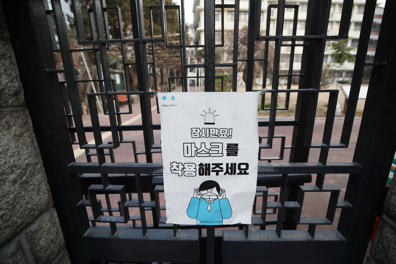신종 코로나바이러스감염증(코로나19) 확산을 막기 위해 마스크 착용 안내 포스터를 교문에 내건 서울 시내 중·고등학교 모습. [연합]