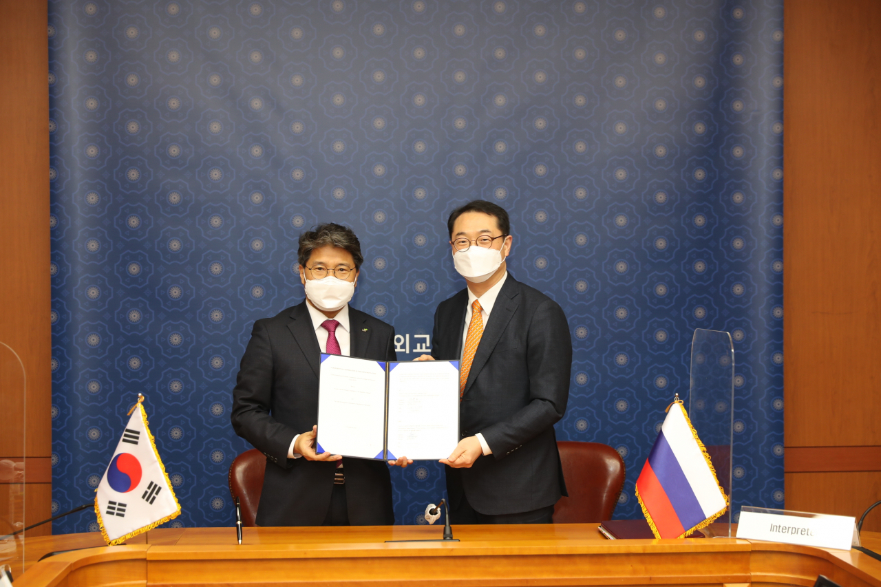 지난 18일 서울 종로구 소재 외교부 청사에서 장충모 한국토지주택공사(LH) 부사장(왼쪽)이 ‘연해주 한·러 경제협력 산업단지’ 개발 사업이행약정서에 서명한 뒤 김건 외교부 차관보와 기념사진을 촬영하고 있다. [한국토지주택공사(LH) 제공]