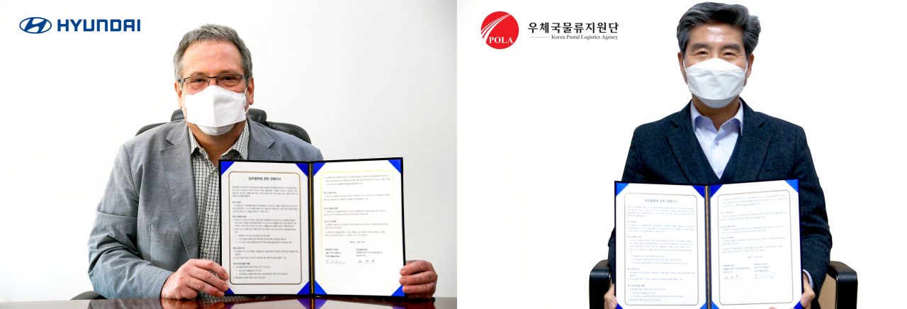 현대자동차 상용개발담당 마틴 자일링어 부사장(왼쪽)과 우체국물류지원단 천장수 이사장이 비대면 방식으로 진행된 ‘마이티 전기차 우편물류 운송차량 실증사업 업무협약(MOU)’ 체결식에서 협약서에 서명한 뒤 기념사진을 찍고 있다. [현대차 제공]