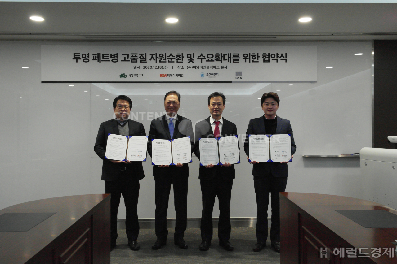 박겸수 구청장(왼쪽에서 세번째)과 민간 기업 대표들이 지난 18일 투명 페트병 자원순환에 관한 업무협약을 맺은 뒤 협약서를 들어보이고 있다. [강북구 제공]