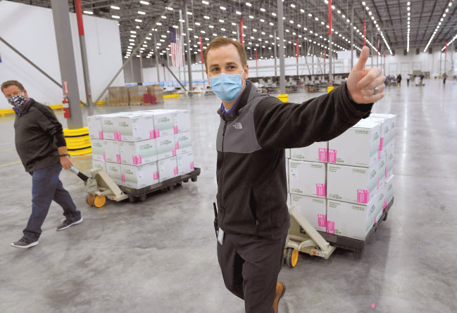 20일(현지시간) 미국 미시시피주 올리브 브랜치에 위치한 의약품 유통업체 매케슨의 유통시설에 보관됐던 모더나 백신을 미 전역으로 운송하기 위해 직원들이 옮기고 있다. 모더나 백신은 이날 트럭에 실려 미국 각 주(州)와 자치령, 주요 도시 등 3700여 곳으로 배송되기 시작했다. [로이터]