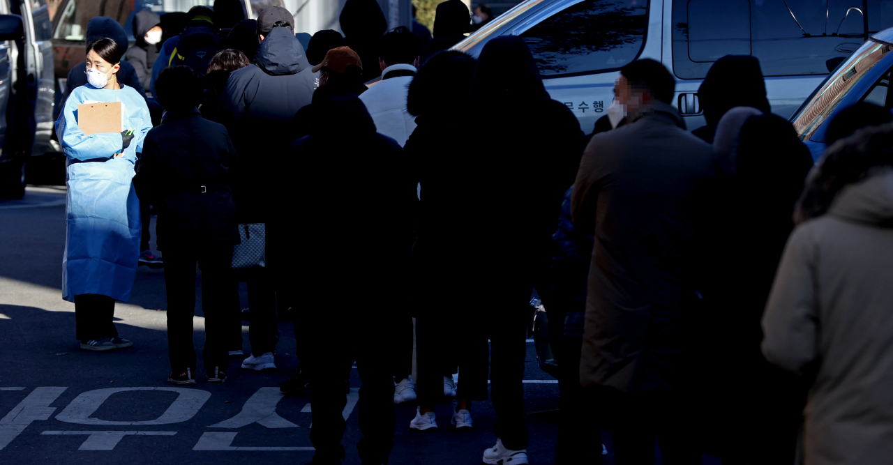 People wait in a long line Saturday for diagnostic checks at a COVID-19 center in Jongno-gu, central Seoul. The government is faced with potential shortage of medical workers with the number of new daily cases sharply rising under the third coronavirus wave. (Yonhap)