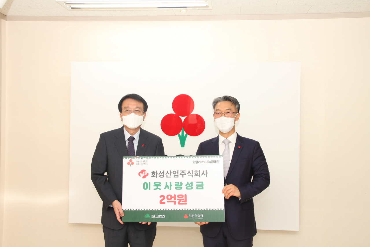 이종원 화성산업 대표이사(오른쪽)가 김수학 대구사회복지공동모금 회장에게 성금을 전달하고 있다.[화성산업 제공]