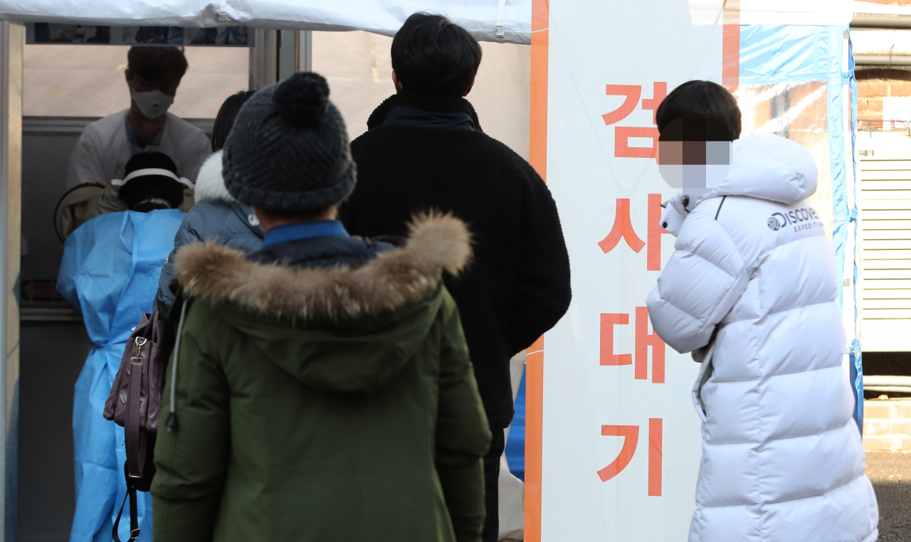 한파가 계속된 21일 서울 국립중앙의료원 코로나19 해외출국선별진료소에서 시민들이 검사를 받기 위해 줄을 서 대기하고 있다. [연합]