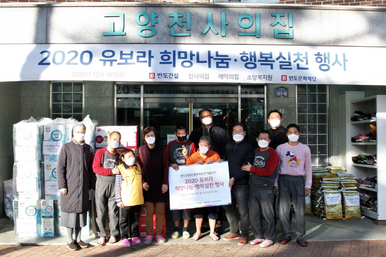 반도건설은 지난 18일 경기 고양시 덕양구에 있는 장애인 생활시설 ‘천사의집’에서 천사의집, 애덕의집, 소망복지원 등 복지관 3곳에 청소기와 쌀, 생활필수품 등을 전달했다. 박현일 반도건설 사장(가운데)과 장순옥 천사의집 원장(왼쪽 세번째) 등이 행사를 마친 뒤 환하게 웃고 있다. [반도건설 제공]