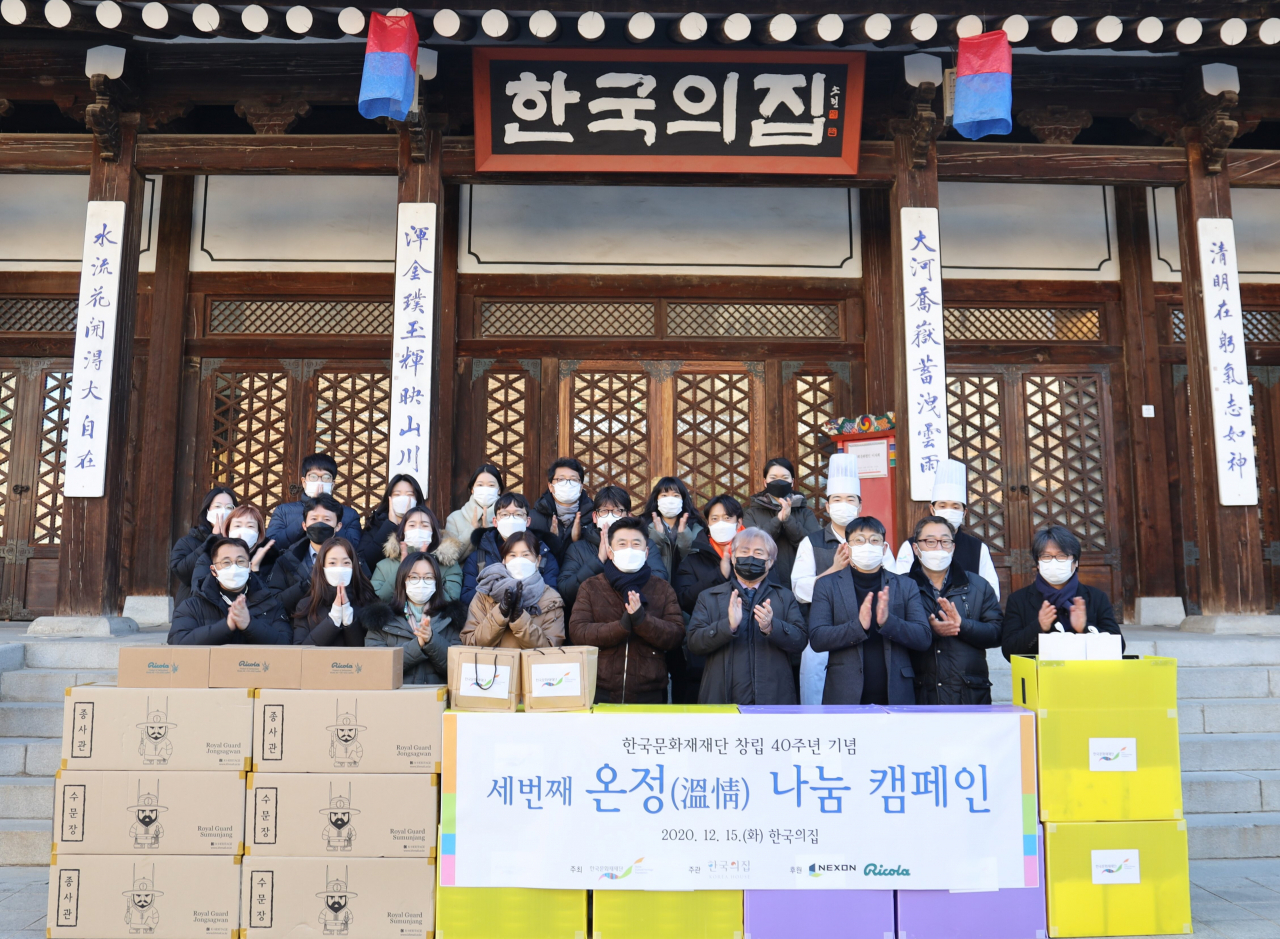 한국문화재재단 진옥섭(앞줄 가운데 검은 마스크) 이사장을 비롯한 직원들이 복지관 등에 전해줄 팥죽과 수문장인형을 포장한뒤 기념촬영을 하고 있다.