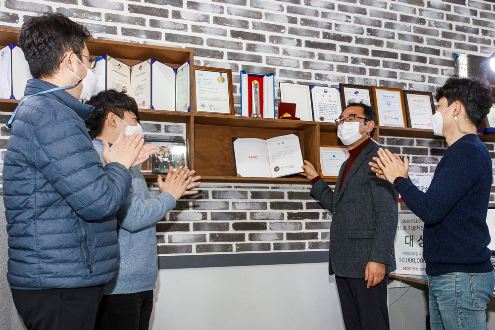 HDC현대산업개발이 주최한 제1회 ‘기술제안공모제’ 비대면 시상식에서 대상을 수상한 피에이치씨탑다운㈜의 김인철 대표(오른쪽 2번째)가 직원들과 함께 기념촬영을 하고 있다. [HDC현대산업개발 제공]
