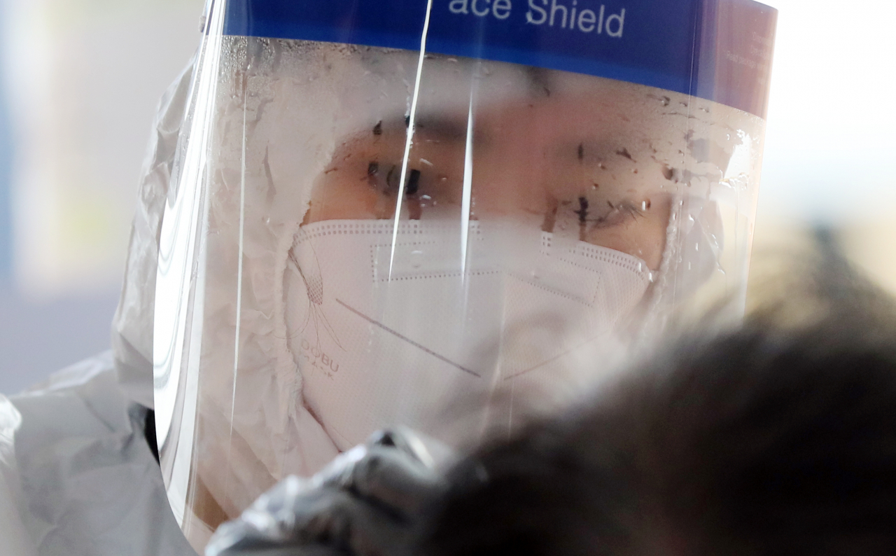 광주광역시에서 지난 22일 하루 동안 36명의 코로나19 확진자가 쏟아진 가운데 23일 오전 광주 북구선별진료소에서 검체를 채취하는 보건소 의료진의 페이스쉴드에 습기가 서려있다. [연합]