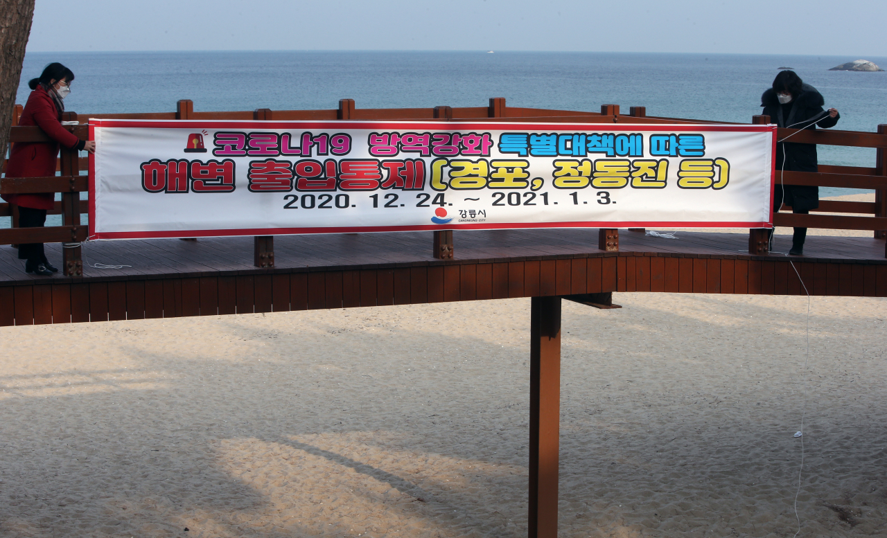 연말연시 해맞이 관광객에 의한 코로나19 대확산이 우려되자 23일 강원 강릉시가 경포 해변 주변에 출입을 차단한다는 현수막을 걸고 있다. [연합]