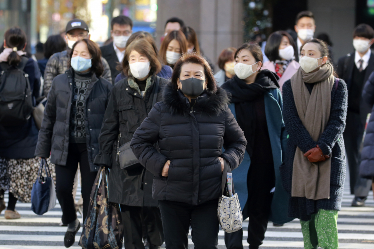 지난 22일 마스크를 착용한 일본 수도 도쿄 주민들이 분주히 걸어가고 있다. [AP]
