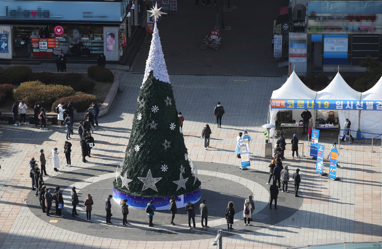People line up around a Christmas tree to get a COVID-19 test in Gyeonggi Province. (Yonhap)